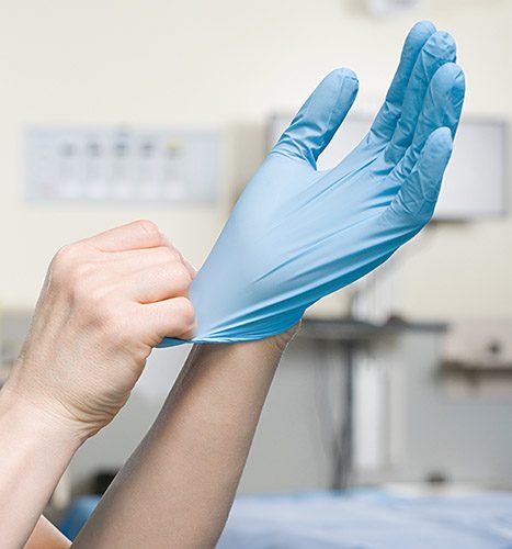 Surgeon putting on glove